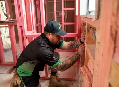 Plumber installing plumbing inside a wall