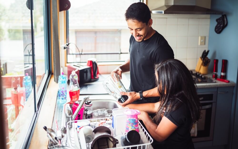 A father washing dishes with his child