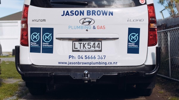 Plumbing van displaying Master Plumbers, Gasfitters, and Drainlayers decals