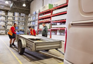 Bunnings employees helping a customer load timber onto a trailer